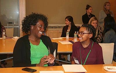 Big and little sister in a conference room smiling while talking