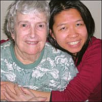 An older lady with a young woman, who used to be big and little sisters, hugging together