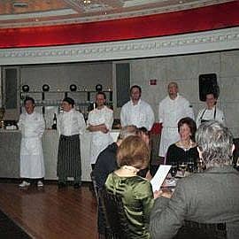 group of chefs standing in front of the kitchen during the Big Sister Boston celebrity chef dinner