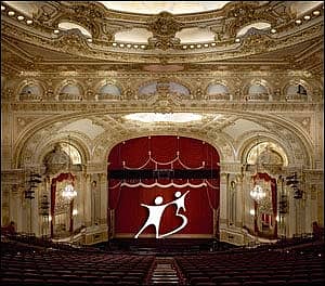 view of a stage at an opera house with red seats and gold fixtures